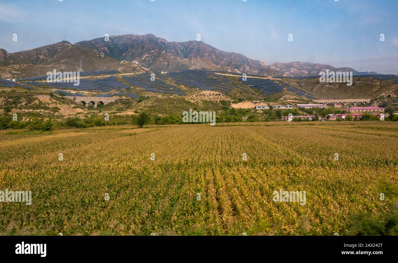 Paysages de montagne et d'agriculture avec panneaux solaires à énergie renouvelable vu de la fenêtre du train Trans-Mongol Express, Chine, Asie Banque D'Images