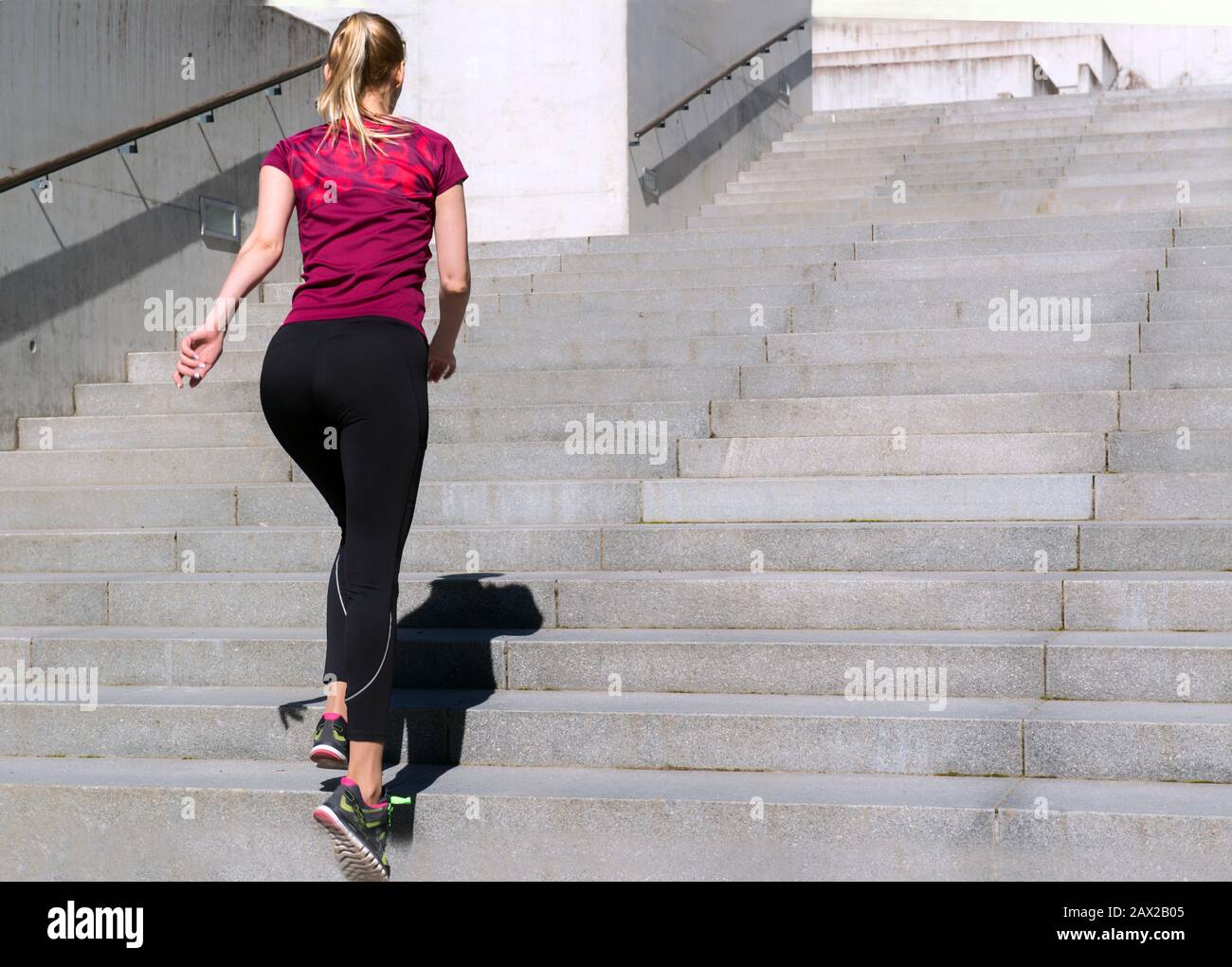 Jeune fille sportive dans un haut et des leggings de jogging dans les escaliers. Jolie femme sportive. Concept de sport et de santé. Banque D'Images