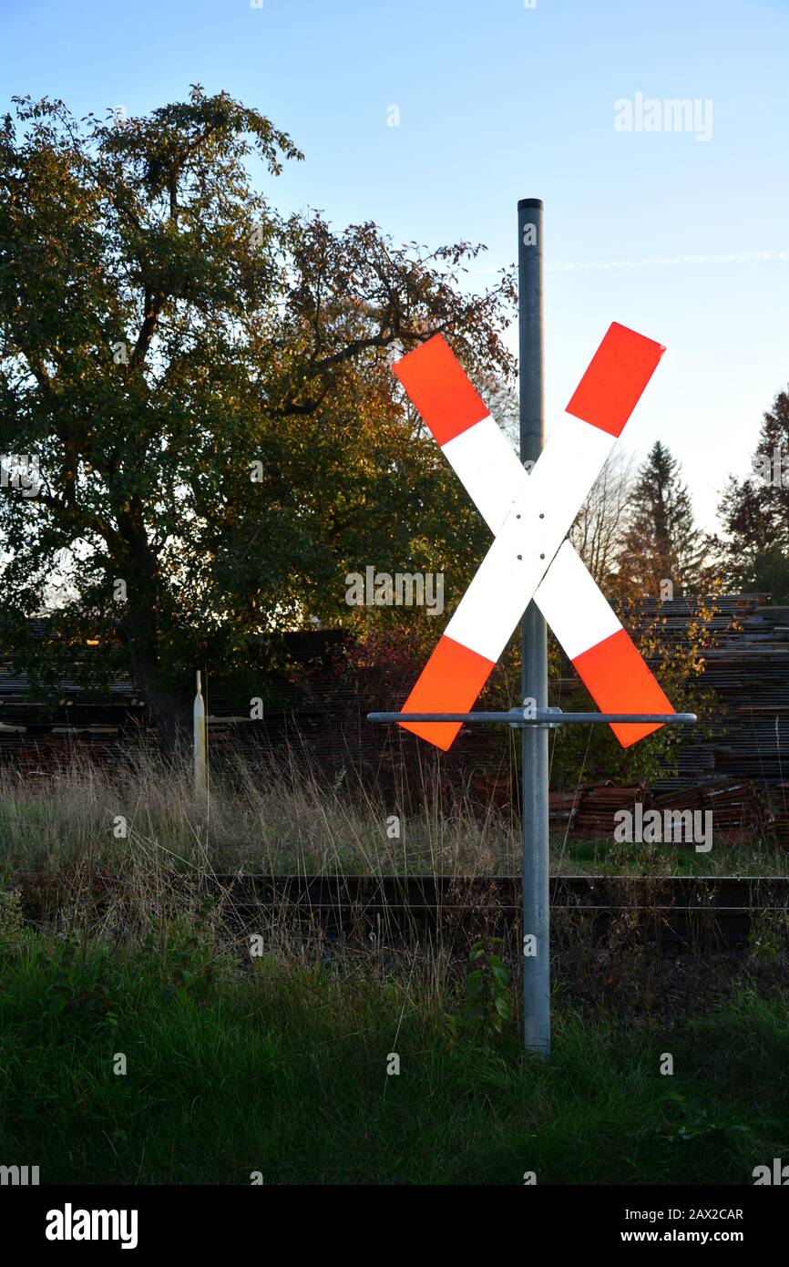Croix de Saint-André avant les rails avec arbre, herbe et bois Banque D'Images