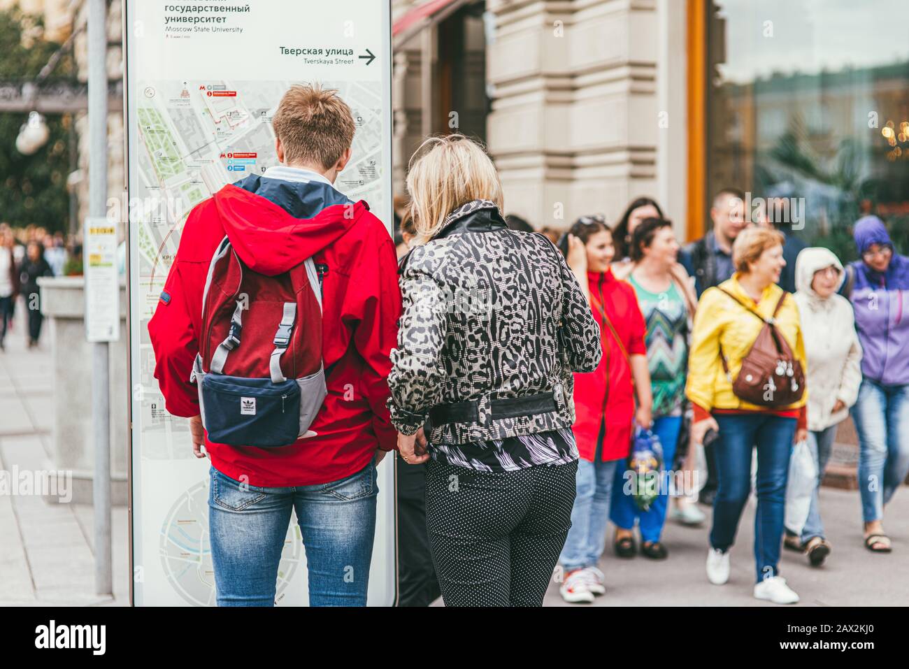 Moscou, Russie - 7 JUILLET 2017. Un homme dans une veste rouge vif, sac à  dos Adidas et jeans bleus avec une femme debout et regardant une carte de  la ville Photo Stock - Alamy