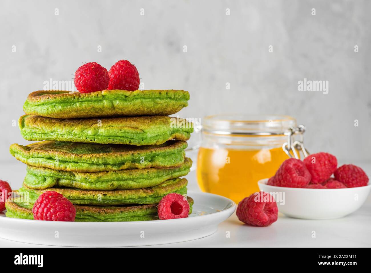 Crêpes vertes avec thé de matcha, framboises et miel. Petit déjeuner en bon état dessert. Gros plan Banque D'Images