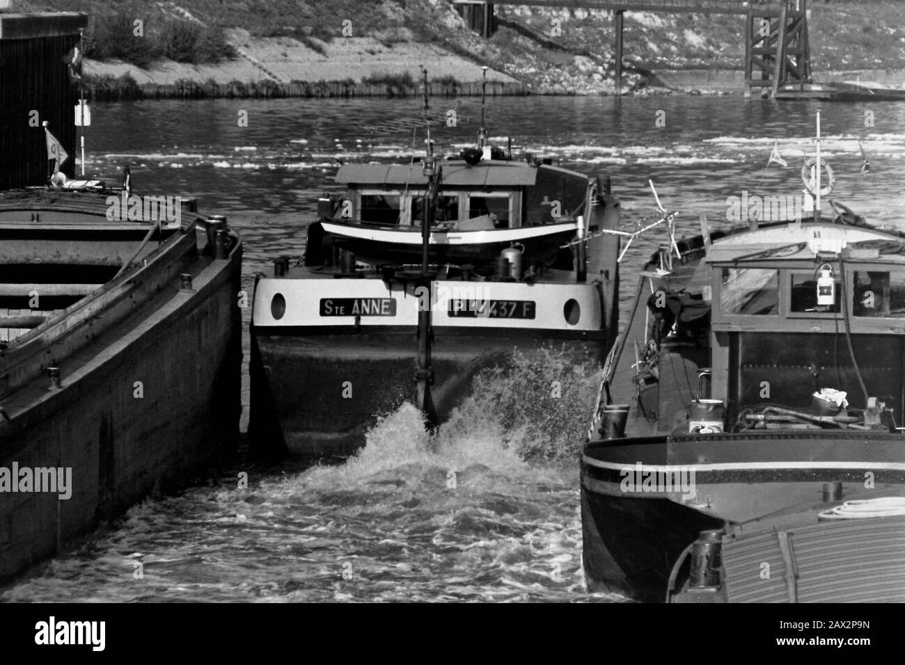 AJAXNETPHOTO. SEPTEMBRE 1971. AMFREVILLE, FRANCE. - SERRAGE SERRÉ - LA FREYCINET PENICHE STE.ANNE, SA CHANCELIÈRE QUI S'EST HISSÉ, QUITTE LA ÉCLUSE À AMFREVILLE PRÈS DE POSES SUR LA SEINE COMME D'AUTRES BARGES ATTENDENT DE SE METTRE EN ROUTE. PHOTO:JONATHAN EASTLAND/AJAX REF:RX7 151204 147 Banque D'Images