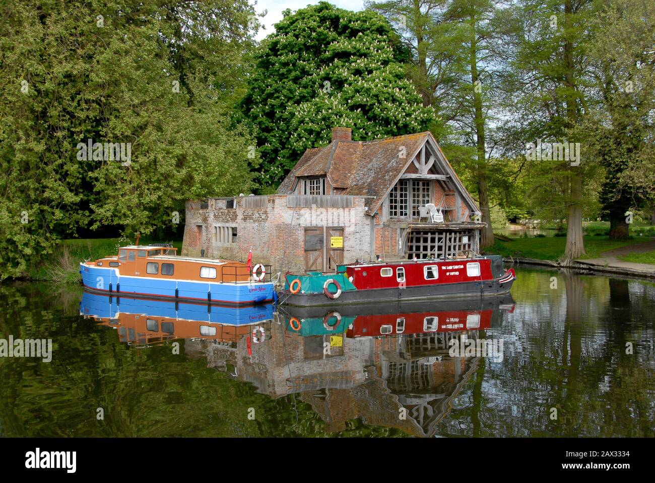 Petit bâtiment au bord de la rivière avec deux bateaux amarrés le long de la Tamise, Angleterre Banque D'Images