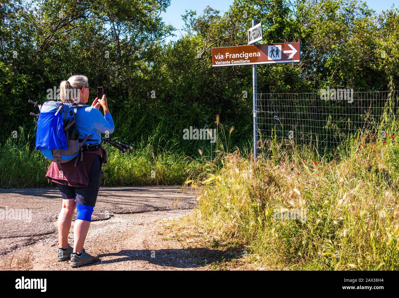 Femme randonneur pèlerin photographiant le chemin du pèlerin ancien Via le panneau de direction de Francigena, Lazio, Italie Banque D'Images