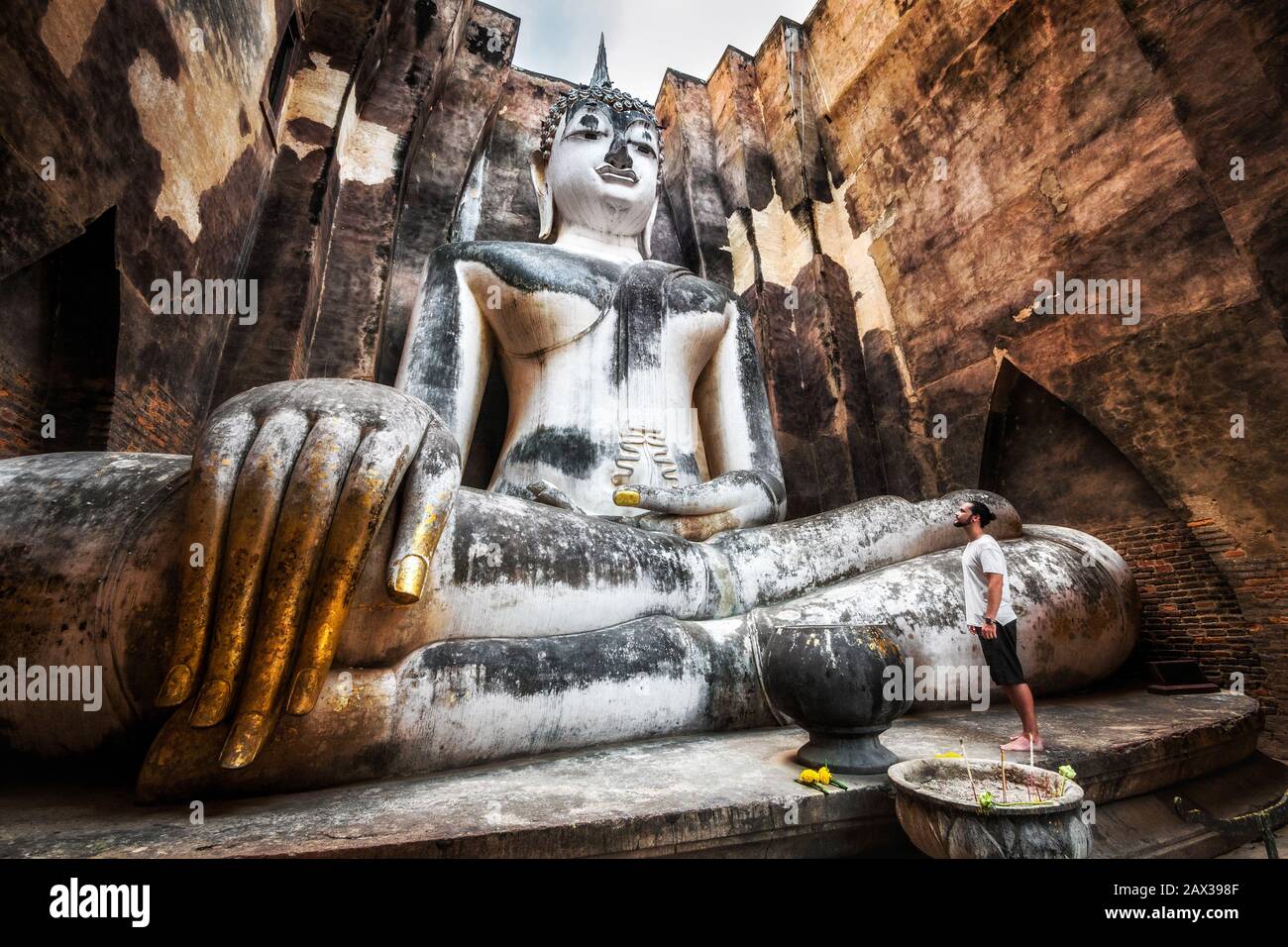 Parc historique de Sukhothai, Thaïlande, voyageur et ancienne statue de Bouddha au temple Wat si Chum. Banque D'Images