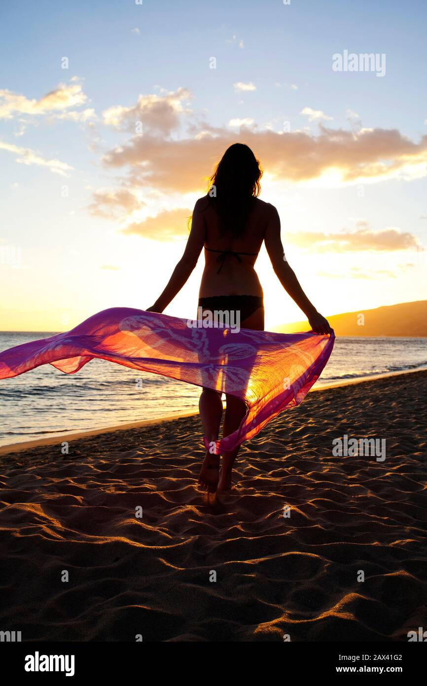 Femme en bonne santé et en forme avec sarong au coucher du soleil à Kihei, Maui, Hawaï. Banque D'Images