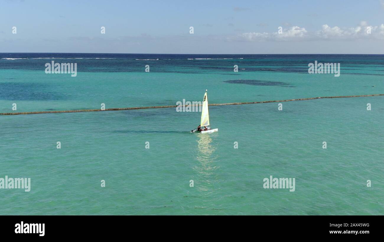 Catamaran naviguant dans les eaux turquoise au large de la plage des Caraïbes en République dominicaine, style de vie amusant et loisirs dans le paradis tropical Banque D'Images