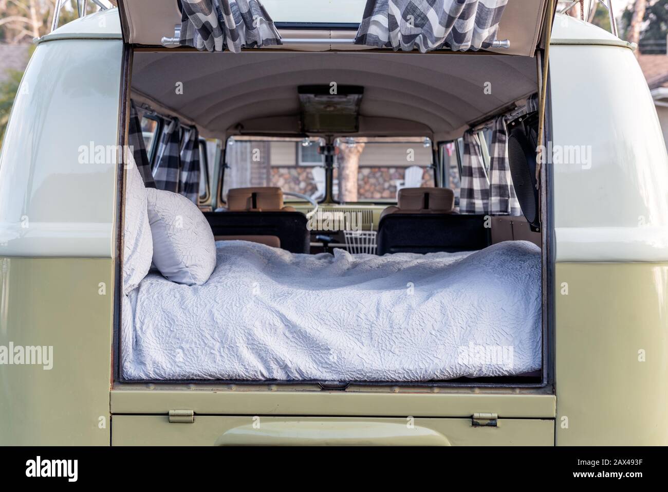 Bus classique de véhicule vintage avec hayon ouvert pour révéler le confortable lit de matelas à l'arrière de la camionnette. Banque D'Images