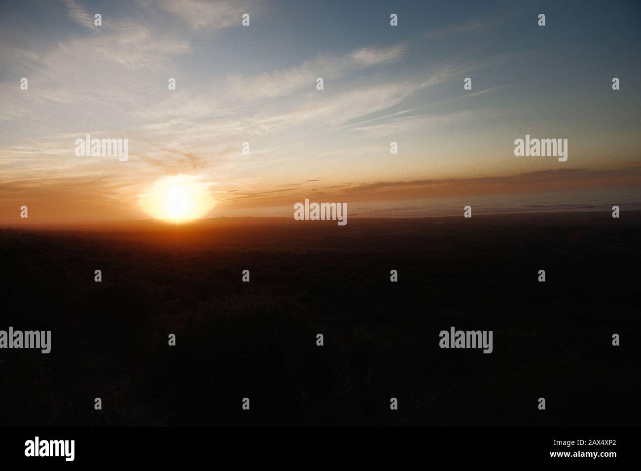 Magnifique nature sombre coucher de soleil en plein air avec des vagues de mer et des montagnes en arrière-plan Banque D'Images