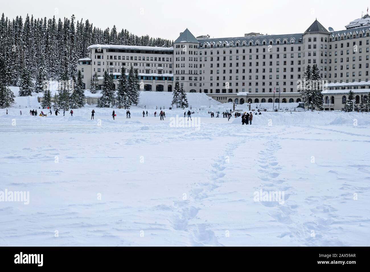Les gens skier, skate et faire de la randonnée sur le lac Louise gelé dans le parc national Banff, en Alberta, au Canada Banque D'Images