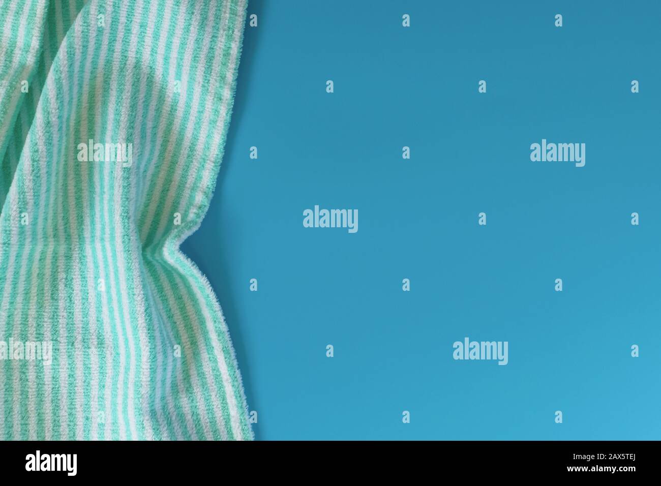 Serviette en coton éponge doux sur fond bleu. Serviette de bain. Articles d'hygiène personnelle. Banque D'Images