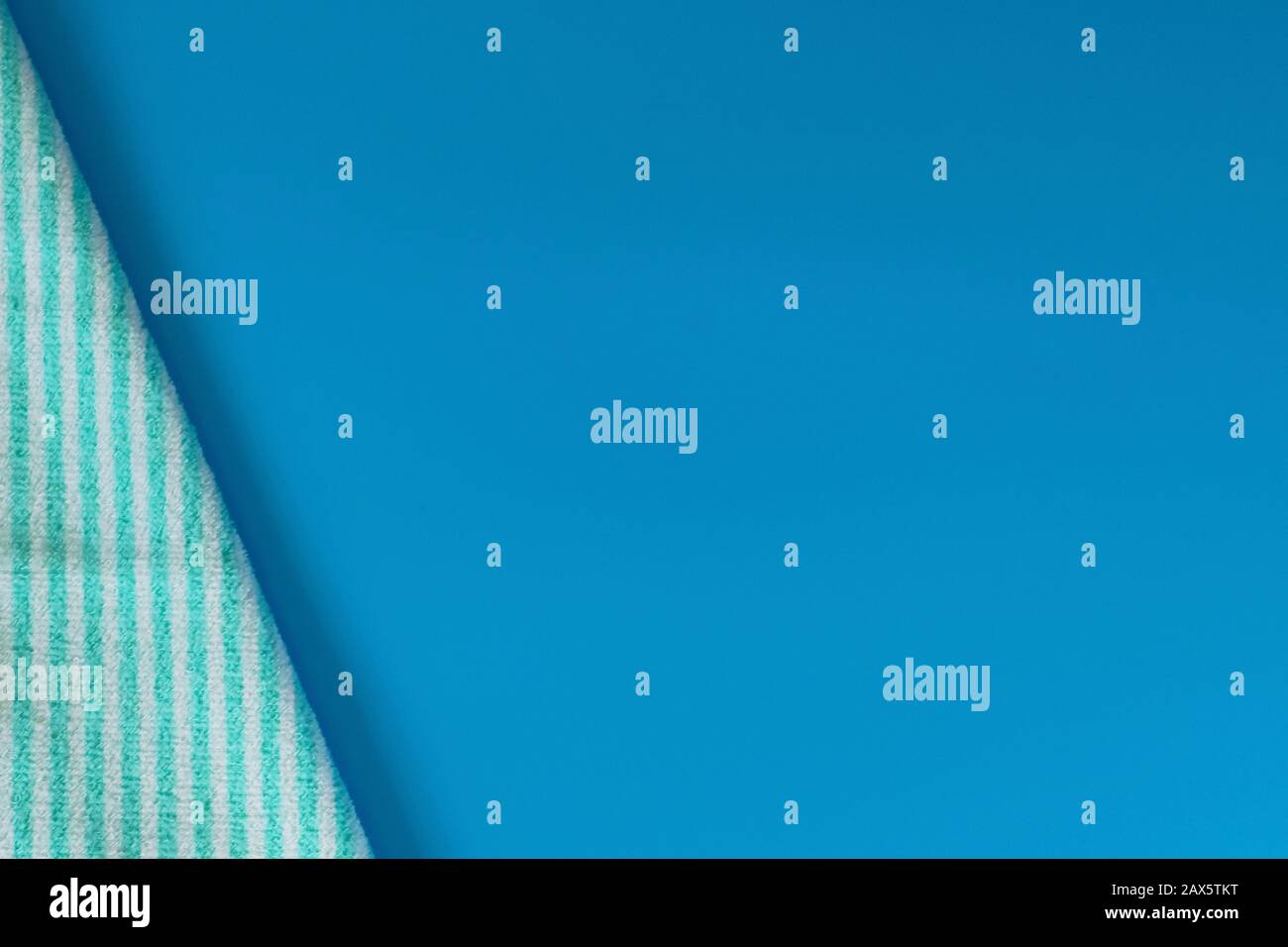 Serviette en coton éponge doux sur fond bleu. Serviette de bain. Articles d'hygiène personnelle. Banque D'Images