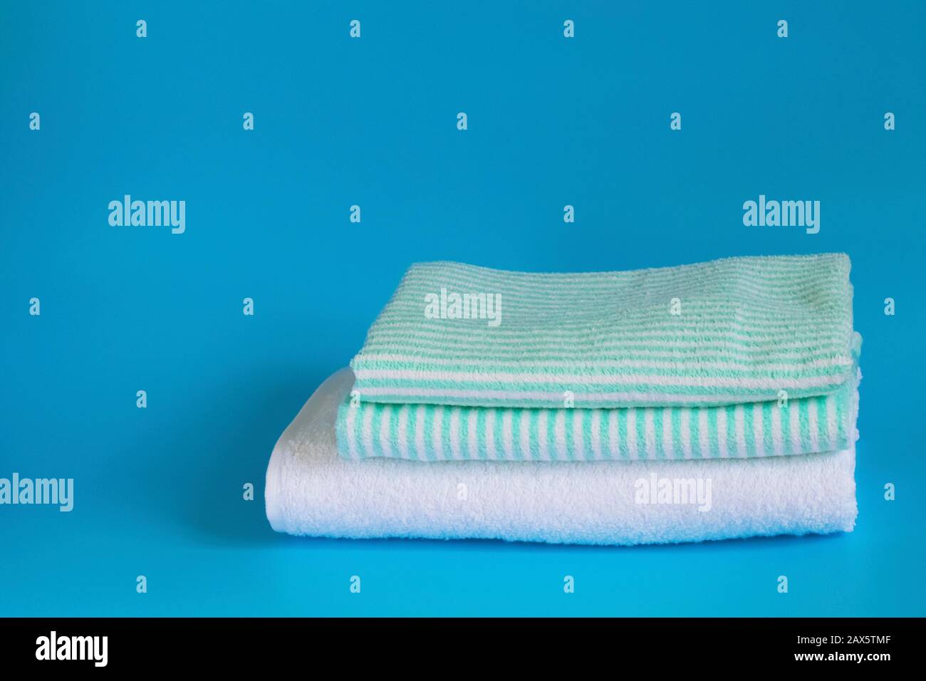 Serviette en coton éponge doux sur fond bleu. Serviette de bain. Articles d'hygiène personnelle. Banque D'Images