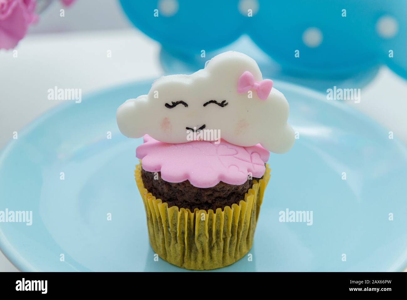 Table de bonbons d'anniversaire avec cupcakes décorés. Cupcake décoré avec un parasol et des gouttes d'eau, arc-en-ciel et nuage avec un visage mignon. Fcu sélectif Banque D'Images