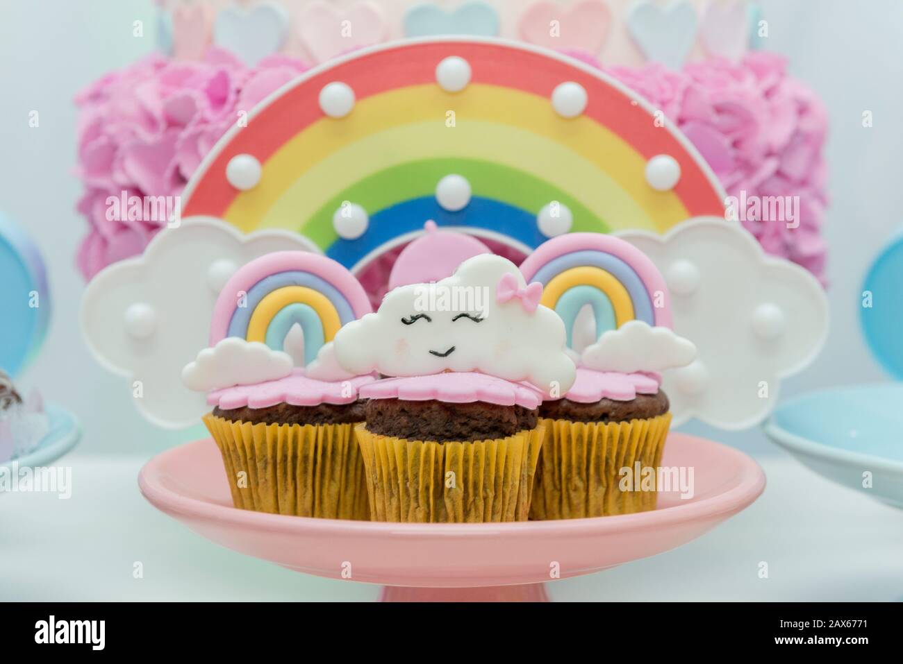 Table de bonbons d'anniversaire avec cupcakes décorés. Cupcake décoré avec un parasol et des gouttes d'eau, arc-en-ciel et nuage avec un visage mignon. Fcu sélectif Banque D'Images