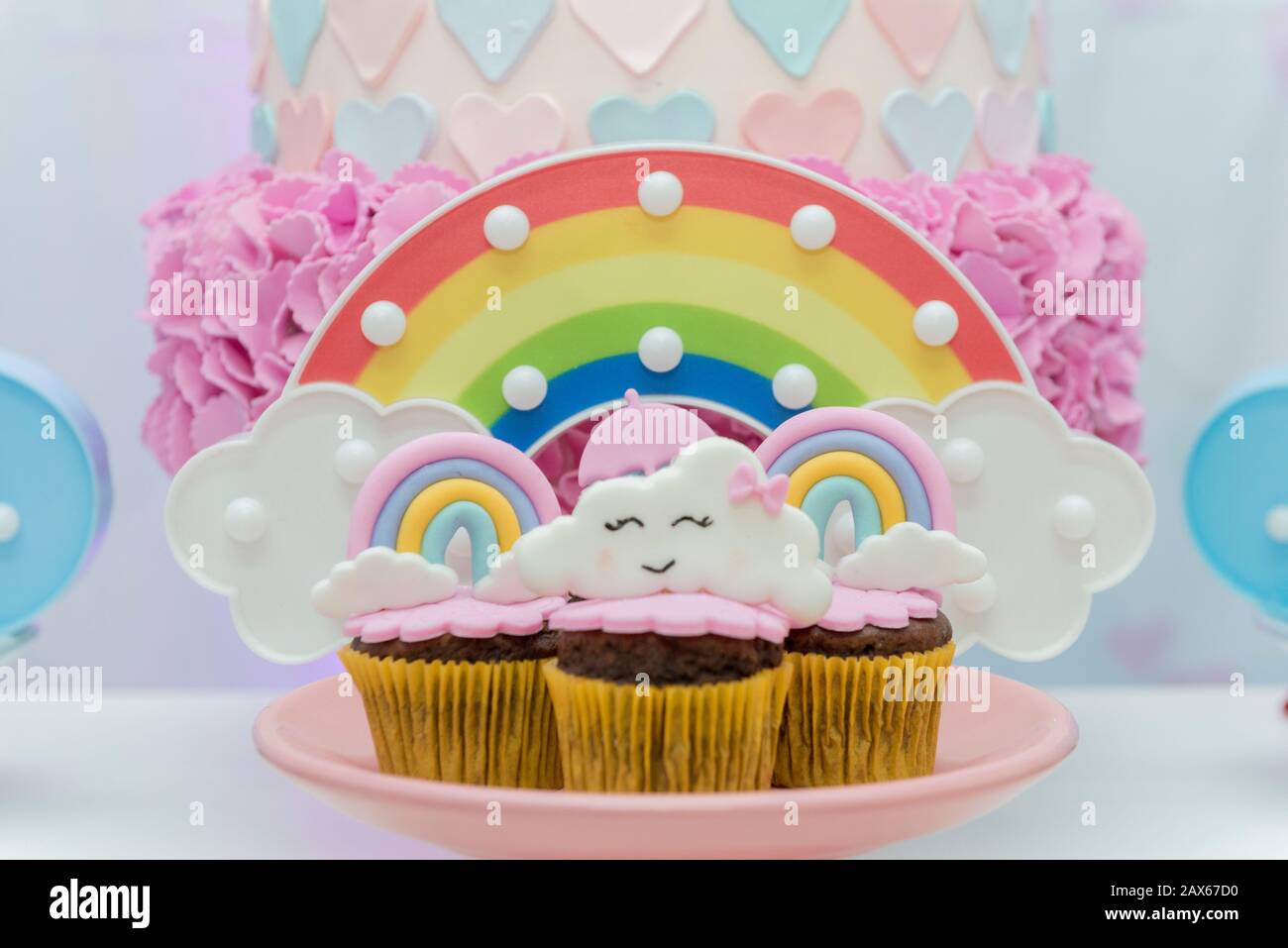 Table de bonbons d'anniversaire avec cupcakes décorés. Cupcake décoré avec un parasol et des gouttes d'eau, arc-en-ciel et nuage avec un visage mignon. Fcu sélectif Banque D'Images