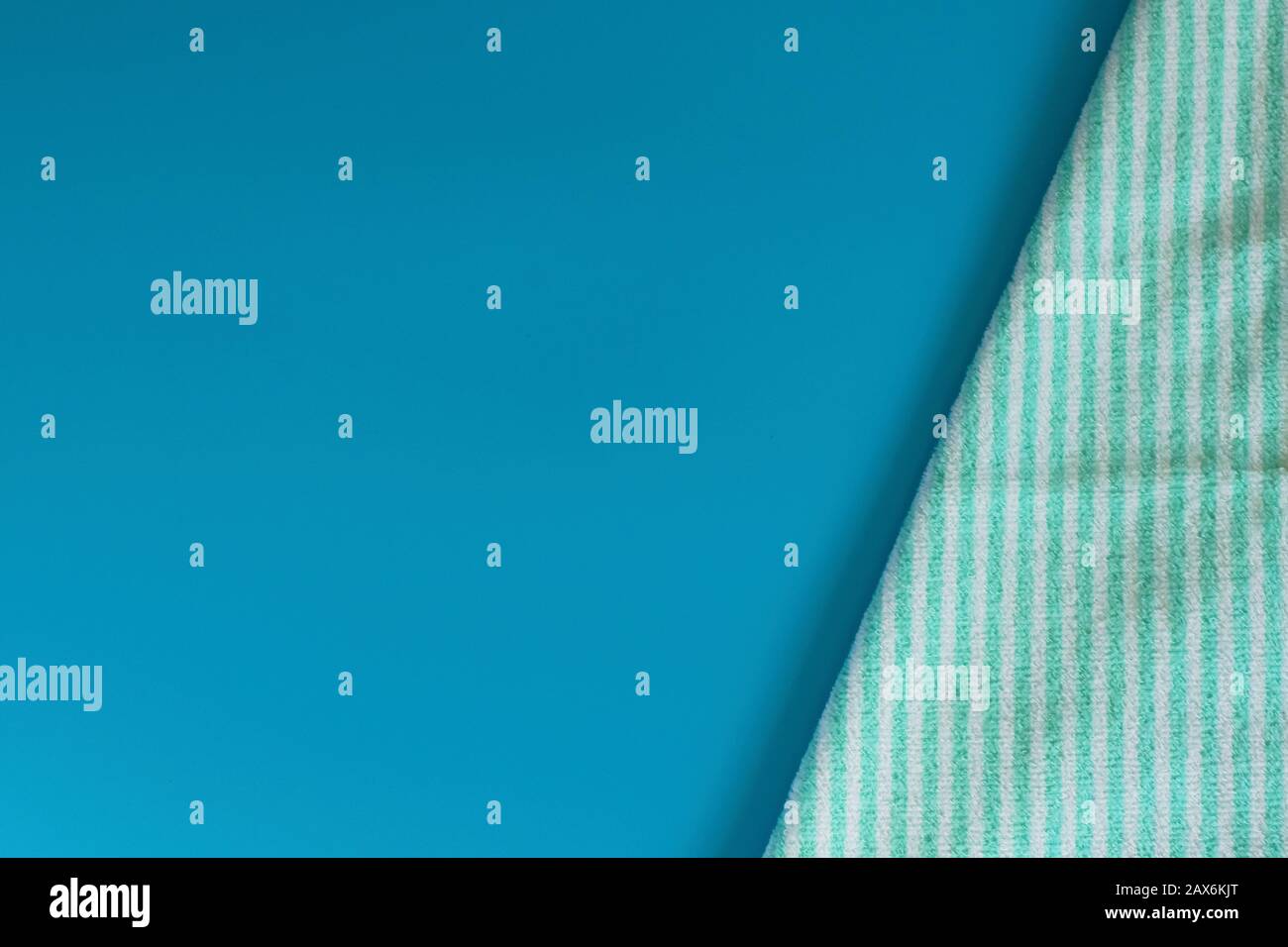 Serviette en coton éponge doux sur fond bleu. Serviette de bain. Articles d'hygiène personnelle. Banque D'Images