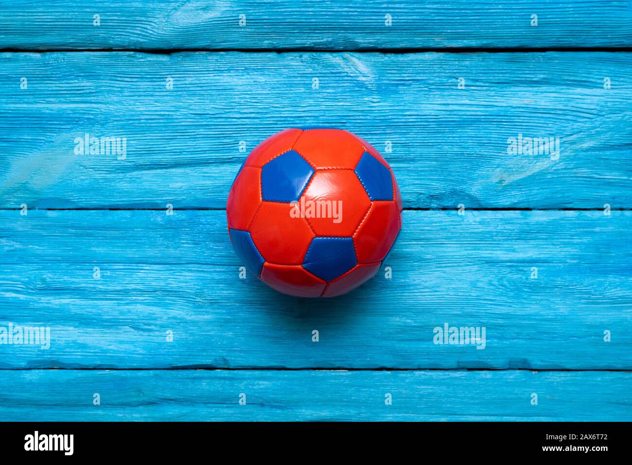 Petite balle de football sur le fond bleu de table en bois. Banque D'Images