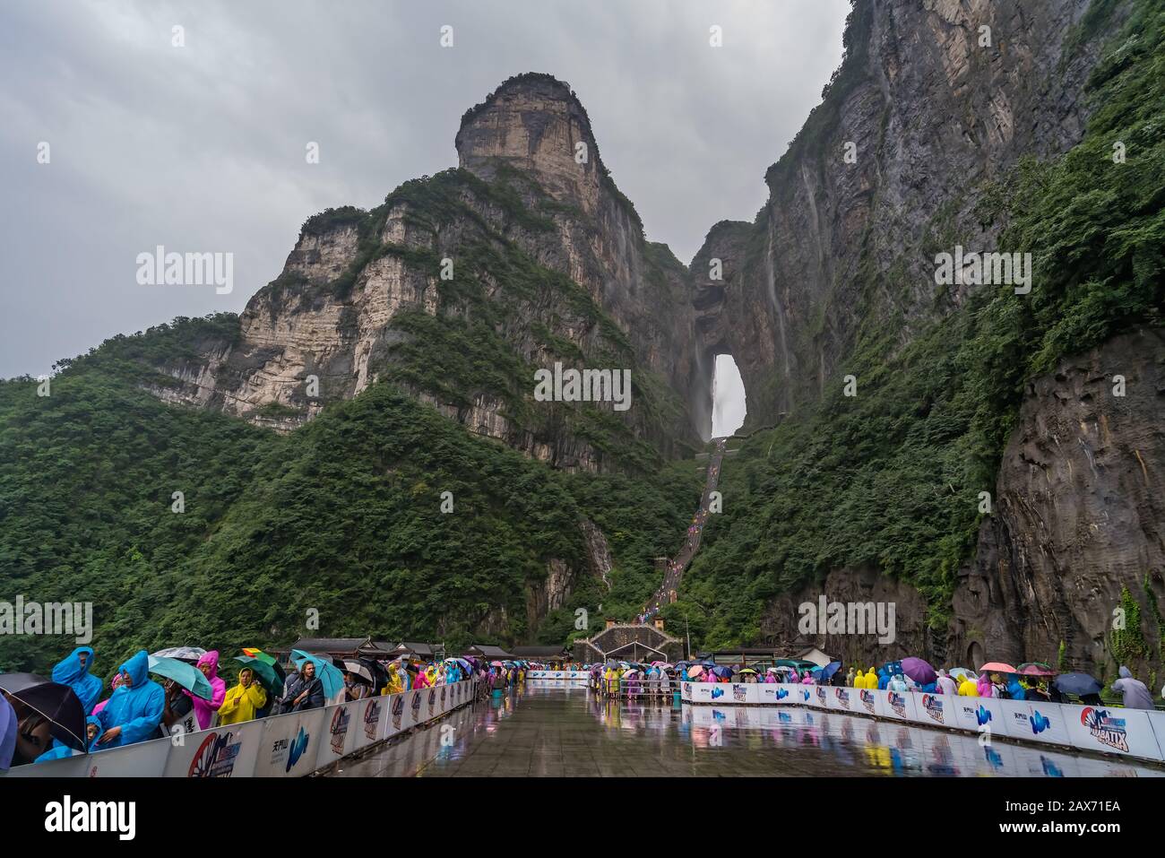 Zhangjiajie, Chine - Août 2019 : foules de touristes Massives attendant dans la pluie torrentielle mousson pour les mini-bus de transport public au pied de Tianmen M Banque D'Images