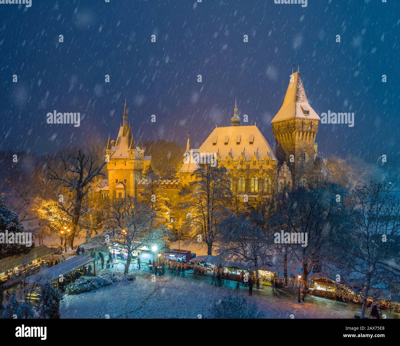 Budapest, Hongrie - marché de Noël dans le parc de la ville enneigée (Varosliget) d'en haut la nuit avec des arbres enneigés et le château de Vajdahunyad Banque D'Images