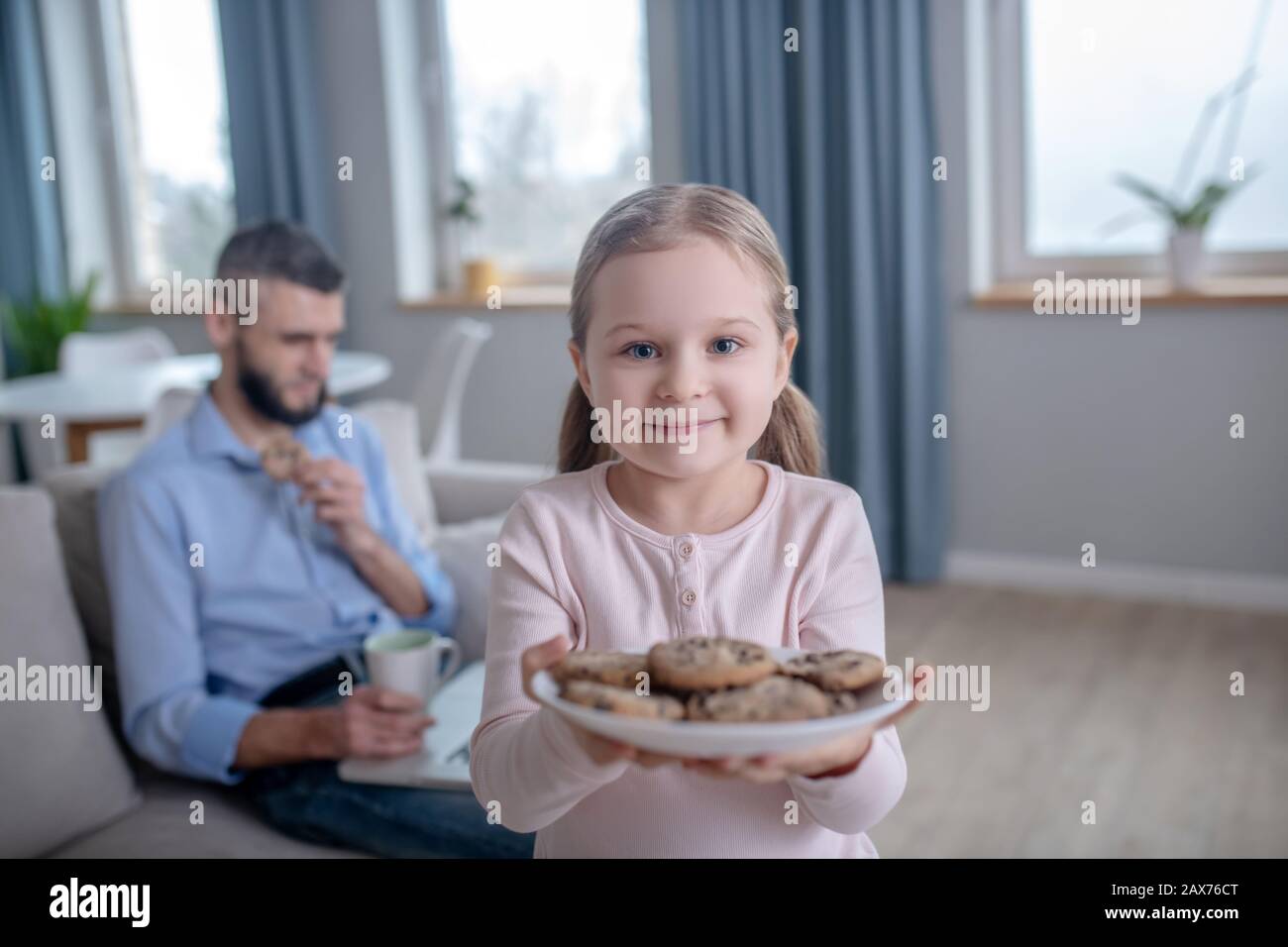 Fille debout avec une plaque de cookies. Banque D'Images