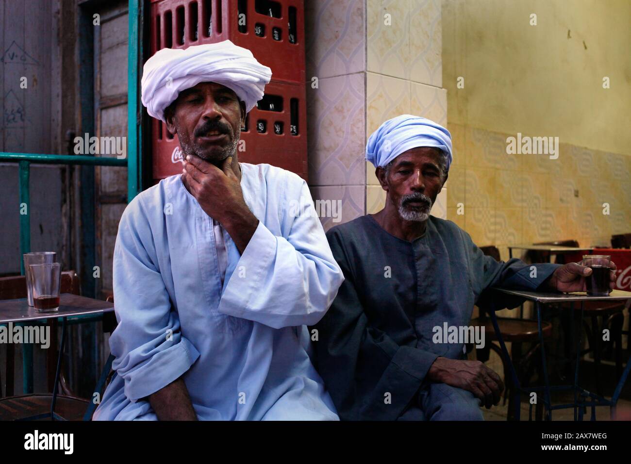 Deux vieux hommes qui travaillent dans le commerce du tourisme obtenir le café dans la soirée le souq d'Assouan, dans le sud de l'Egypte. Banque D'Images