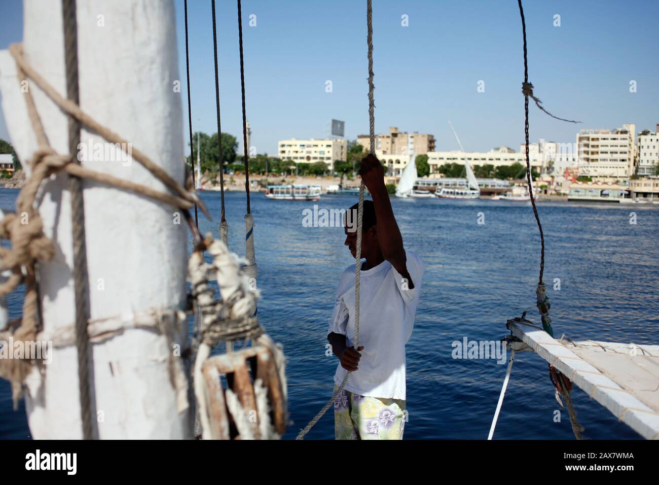 Egypte - un garçon est prêt à ajuster la vente sur un felucca sur le Nil à Assouan. Banque D'Images