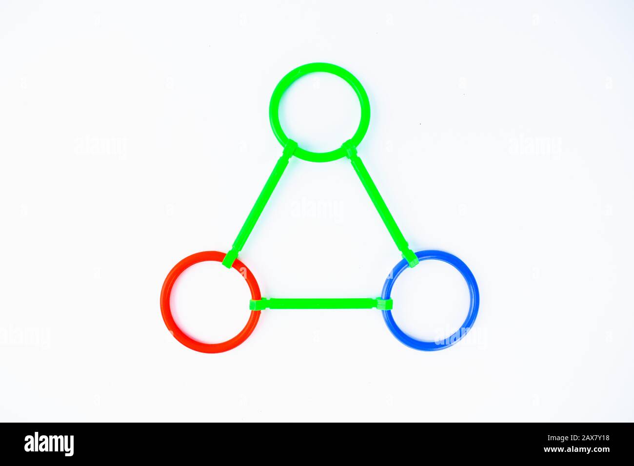 Forme triangulaire constituée de jouets en plastique à mouvement de forme circulaire et ligne sur fond blanc Banque D'Images