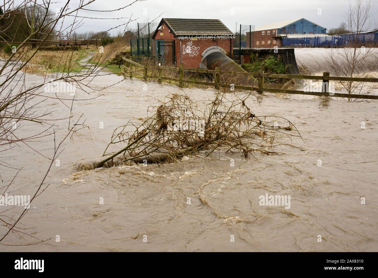 Storm ciara, River irwell éclate ses banques avec des bâtiments industriels en arrière-plan à radcliffe bury lancashire royaume-uni Banque D'Images