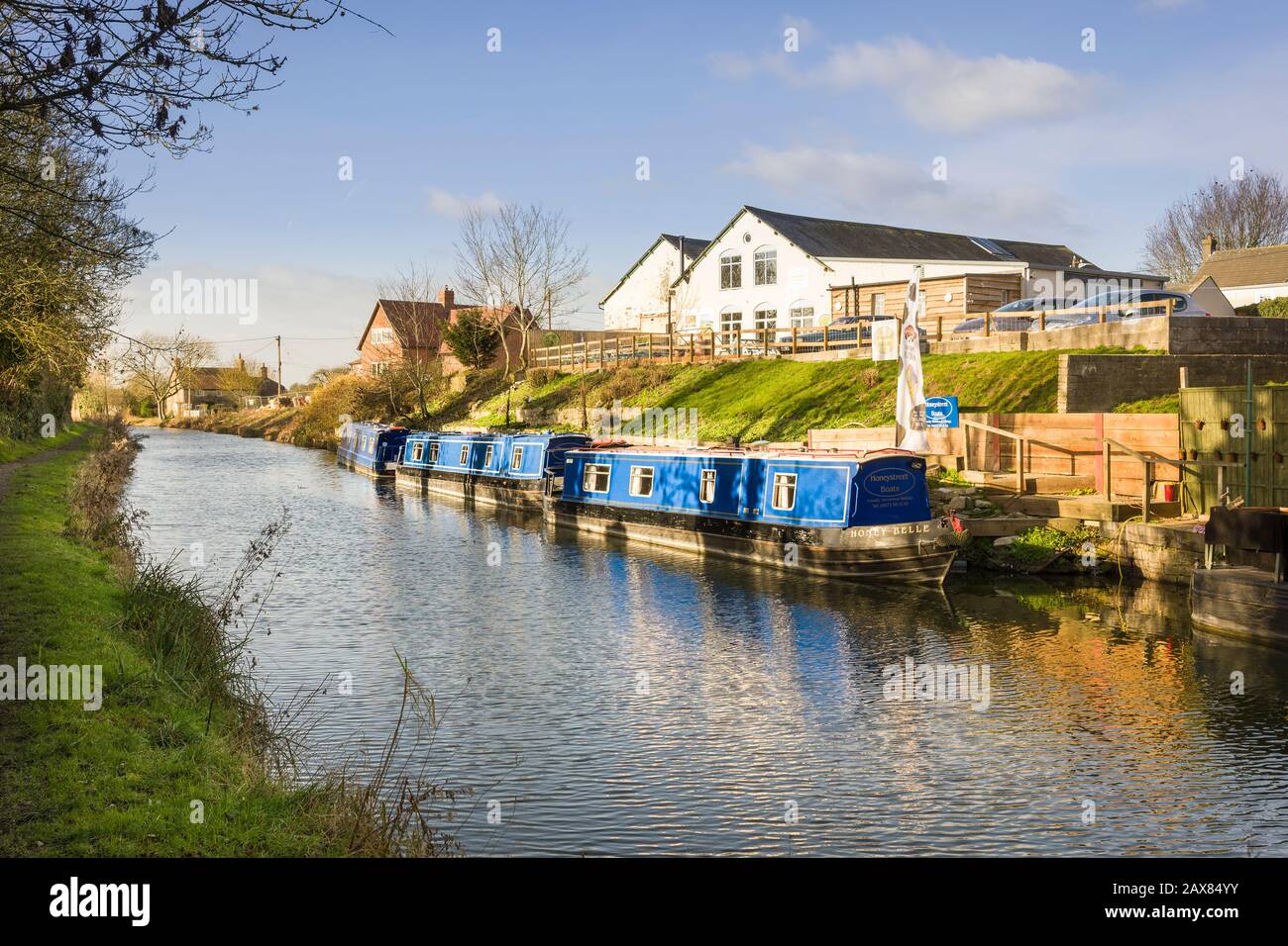 Un paysage ensoleillé et calme en janvier montrant le canal Kennet et Avon et des bateaux étroits amarrés à Honeystreet dans la vallée de Pewsey dans le Wiltshire E Banque D'Images