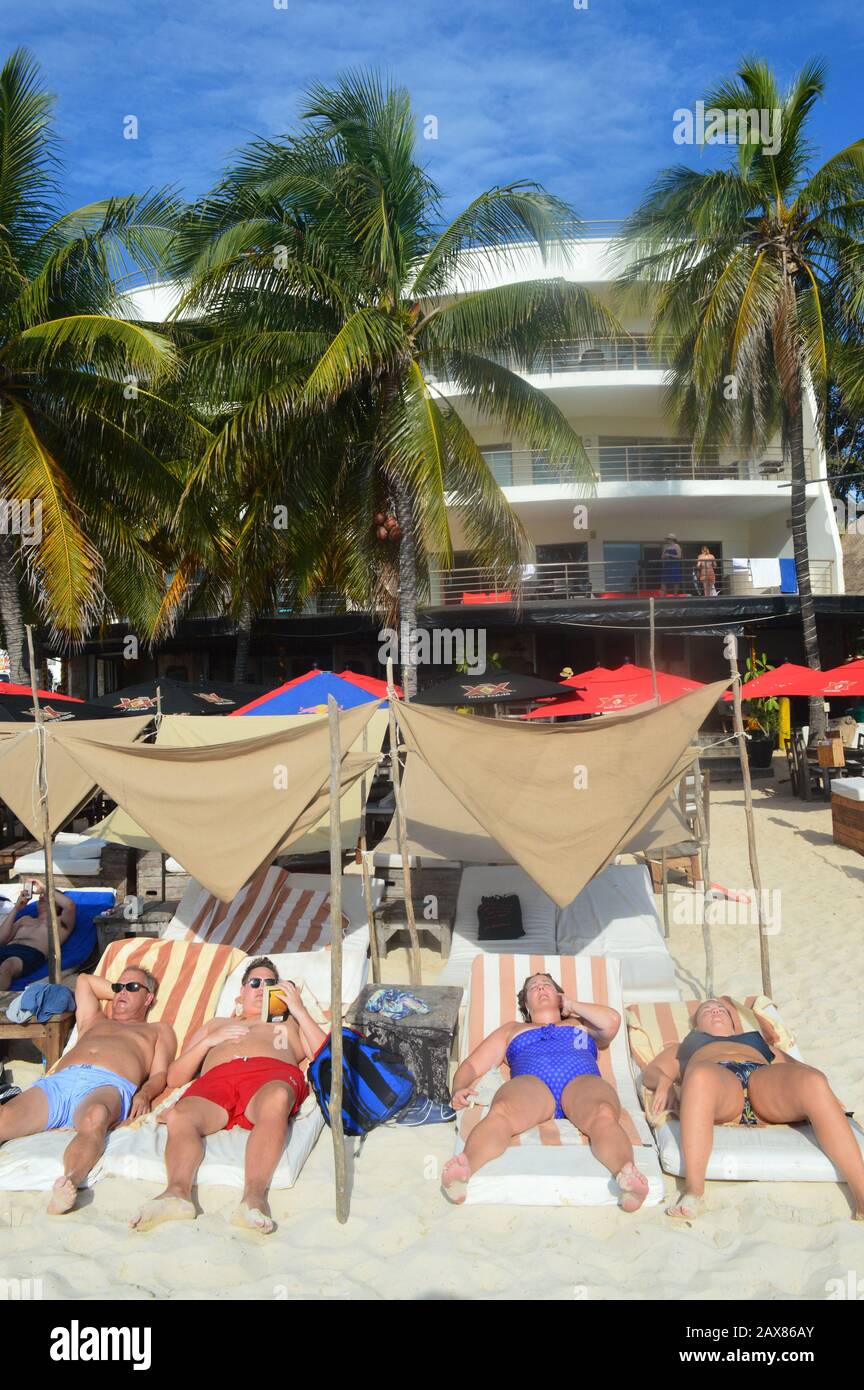 Touristes récemment arrivés, bains de soleil sur la plage. Ce comportement non-lié peut entraîner des coups de soleil, des coups de soleil ou des coups de chaleur. Playa del Carmen, Mexique Banque D'Images