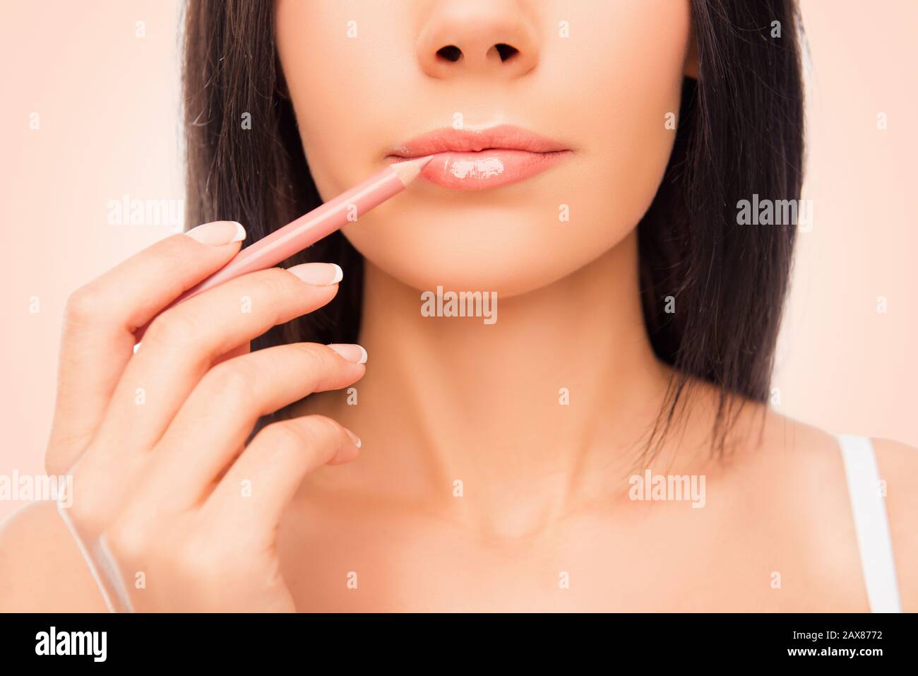 Gros plan photo de la jeune femme faisant le maquillage avec la lèvre de la doublure Banque D'Images