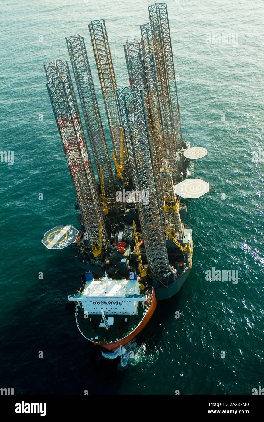 Vue aérienne d'un navire de transport transportant 3 plates-formes de forage au port de Sharjah pour le remontage. Banque D'Images