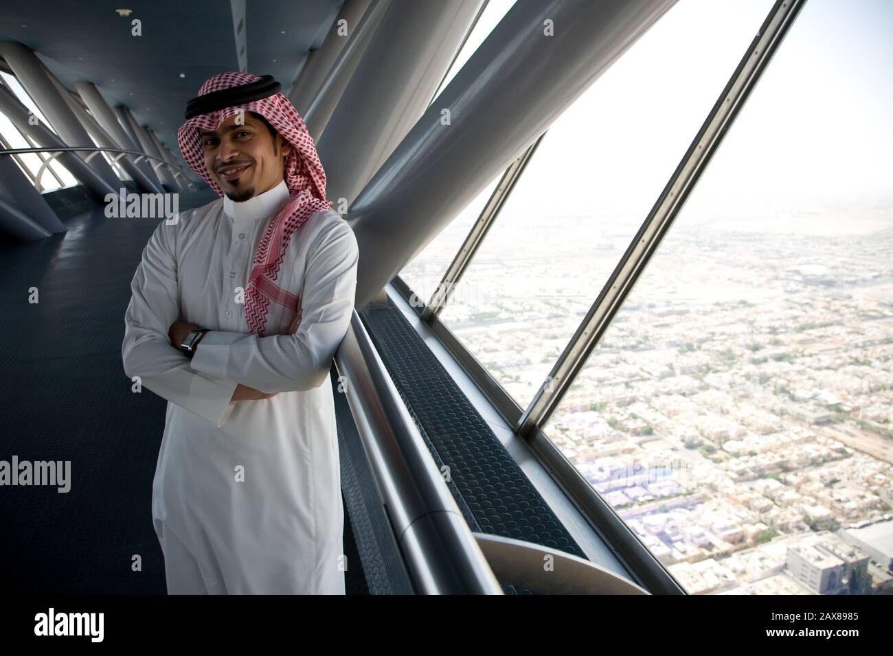 Homme debout dans une tour moderne surplombant la ville de Riyad, en Arabie Saoudite. Banque D'Images