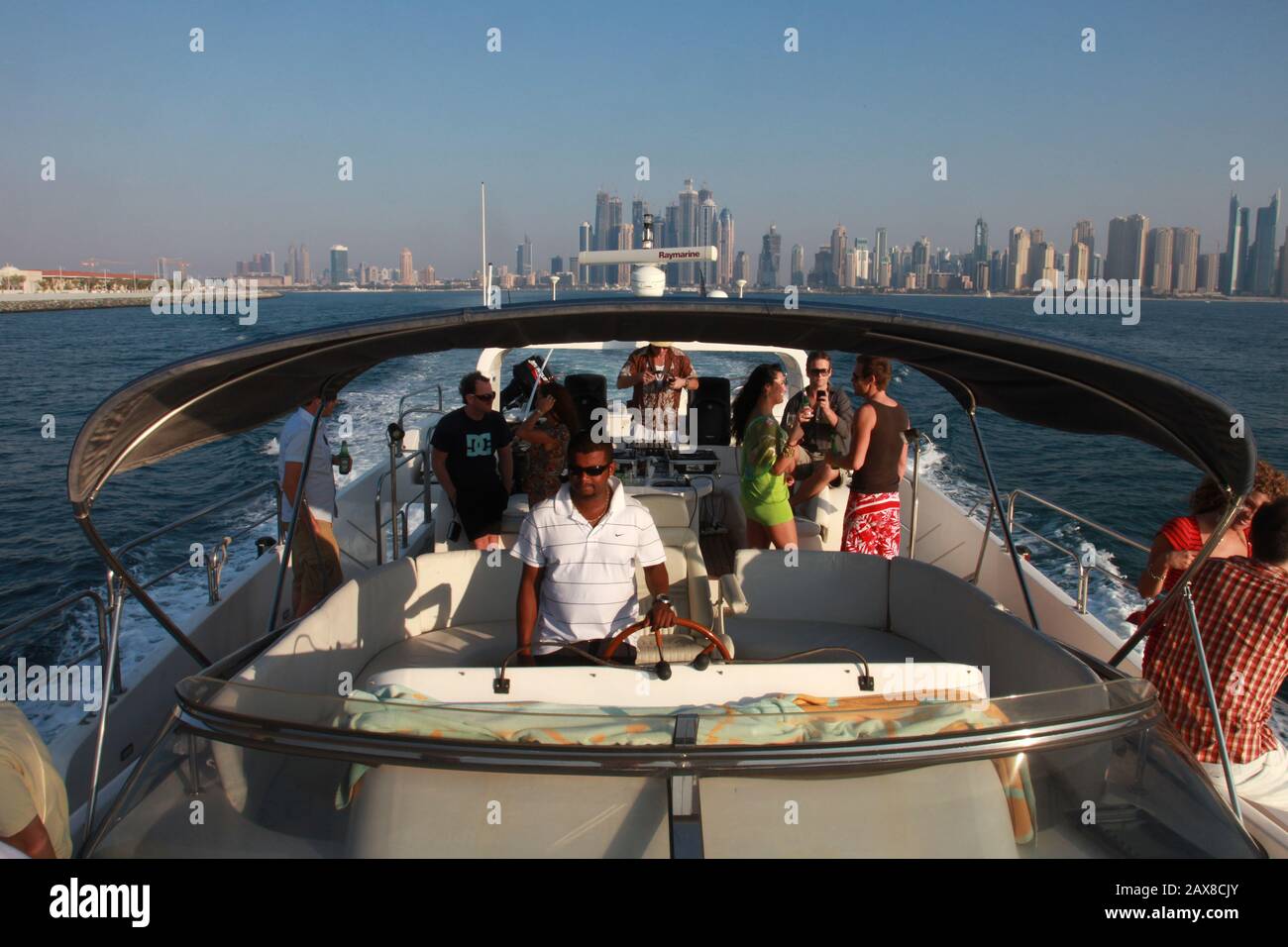 Une fête sur un yacht à Dubaï avec vue sur le port de plaisance de Dubaï en arrière-plan. Dubaï, Émirats arabes Unis. Banque D'Images