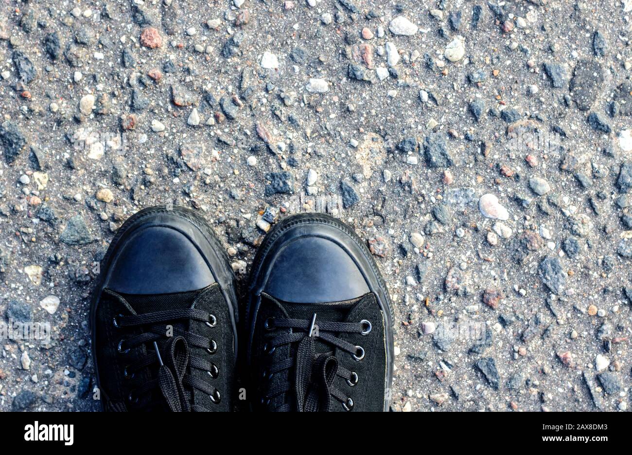 Chaussures noires sur l'asphalte Banque D'Images