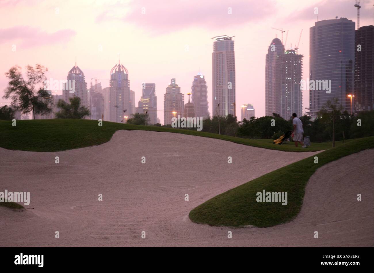Un golfeur fait mal pour terminer son match avant le coucher du soleil, Dubaï, Émirats arabes Unis. Banque D'Images