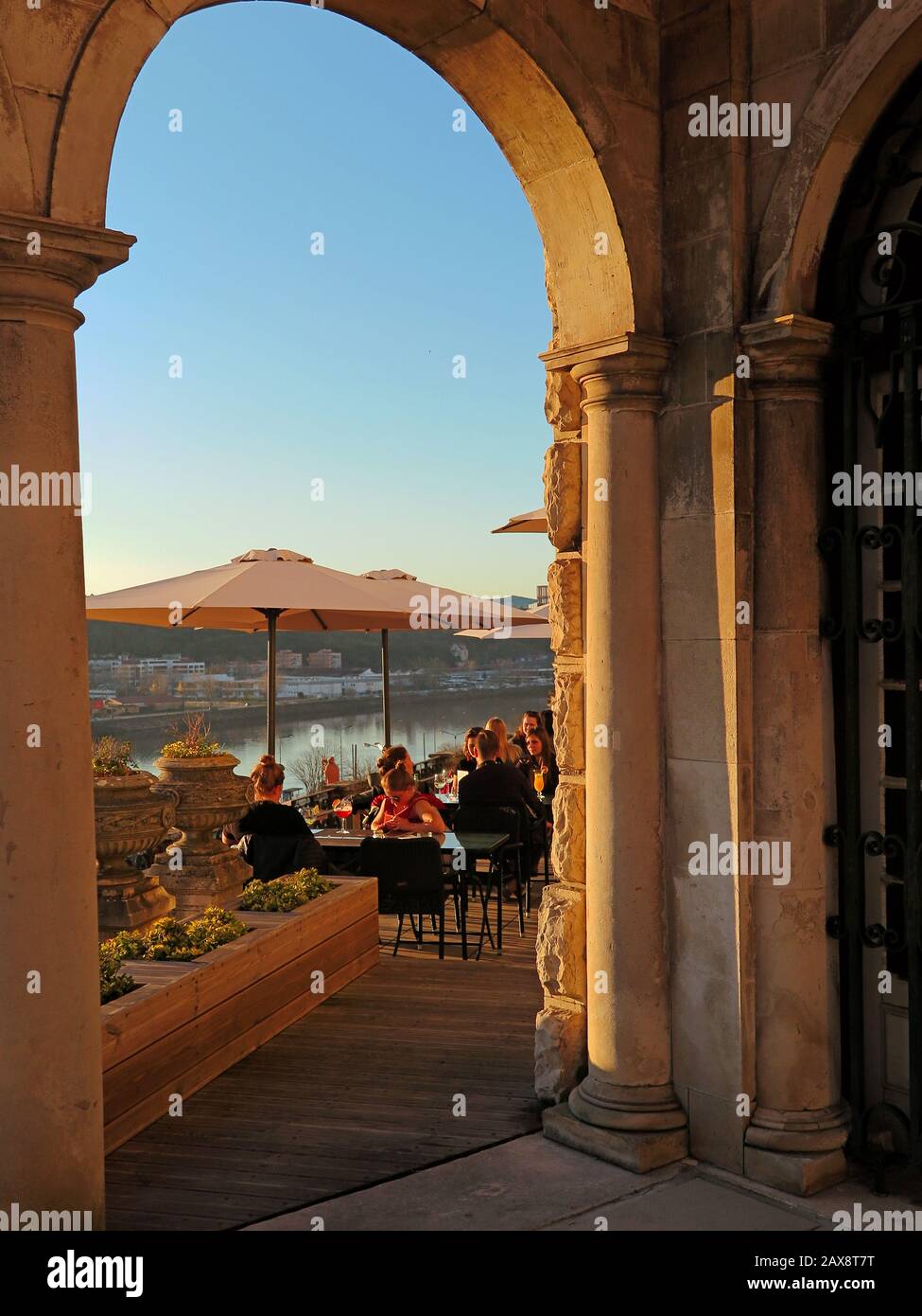 Grâce à l'arche, vous pouvez voir des gens apprécier le restaurant. La rivière et la rive opposée en arrière-plan. Banque D'Images