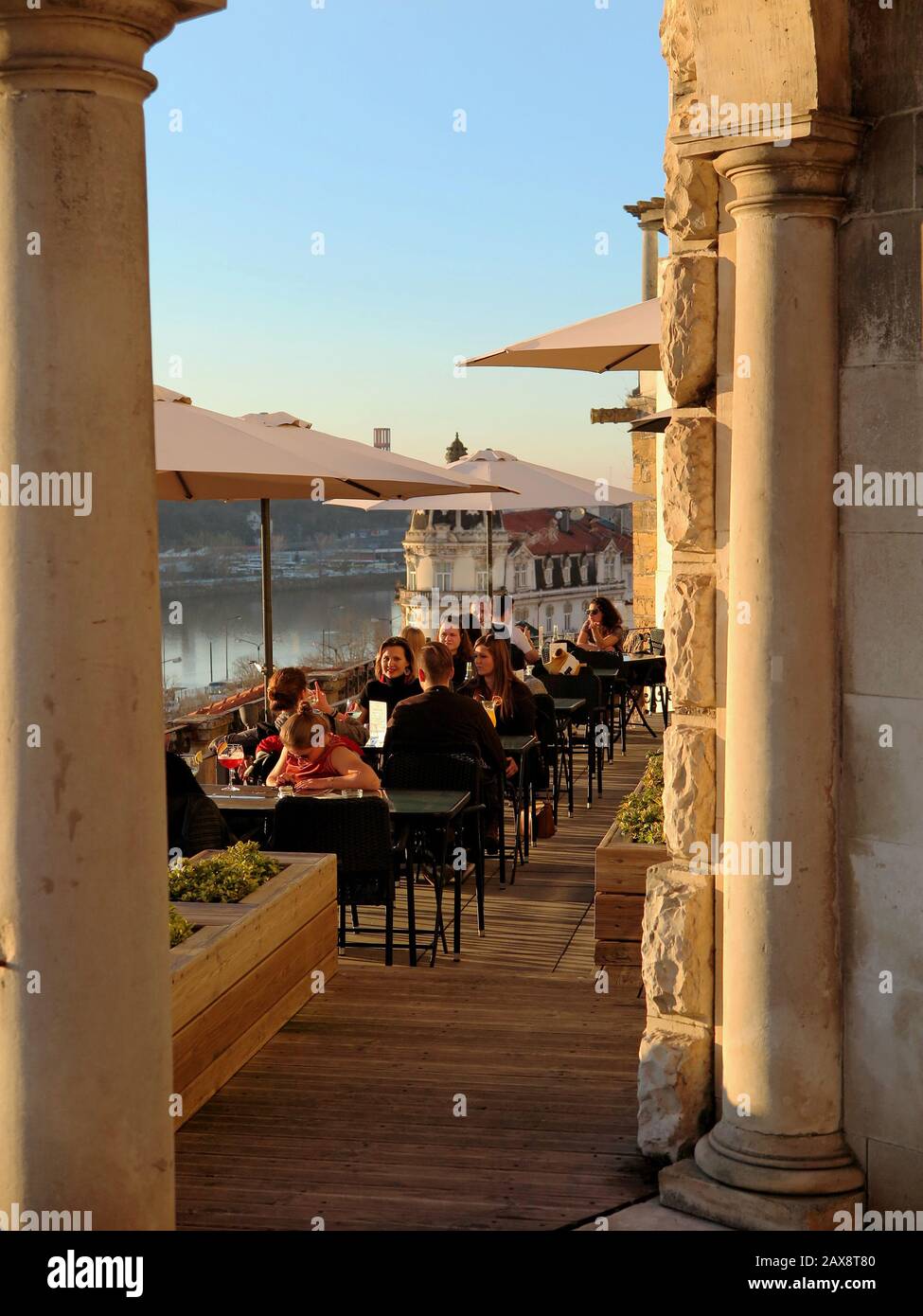 Grâce à l'arche, vous pouvez voir des gens apprécier le restaurant. La rivière et la rive opposée en arrière-plan. Banque D'Images
