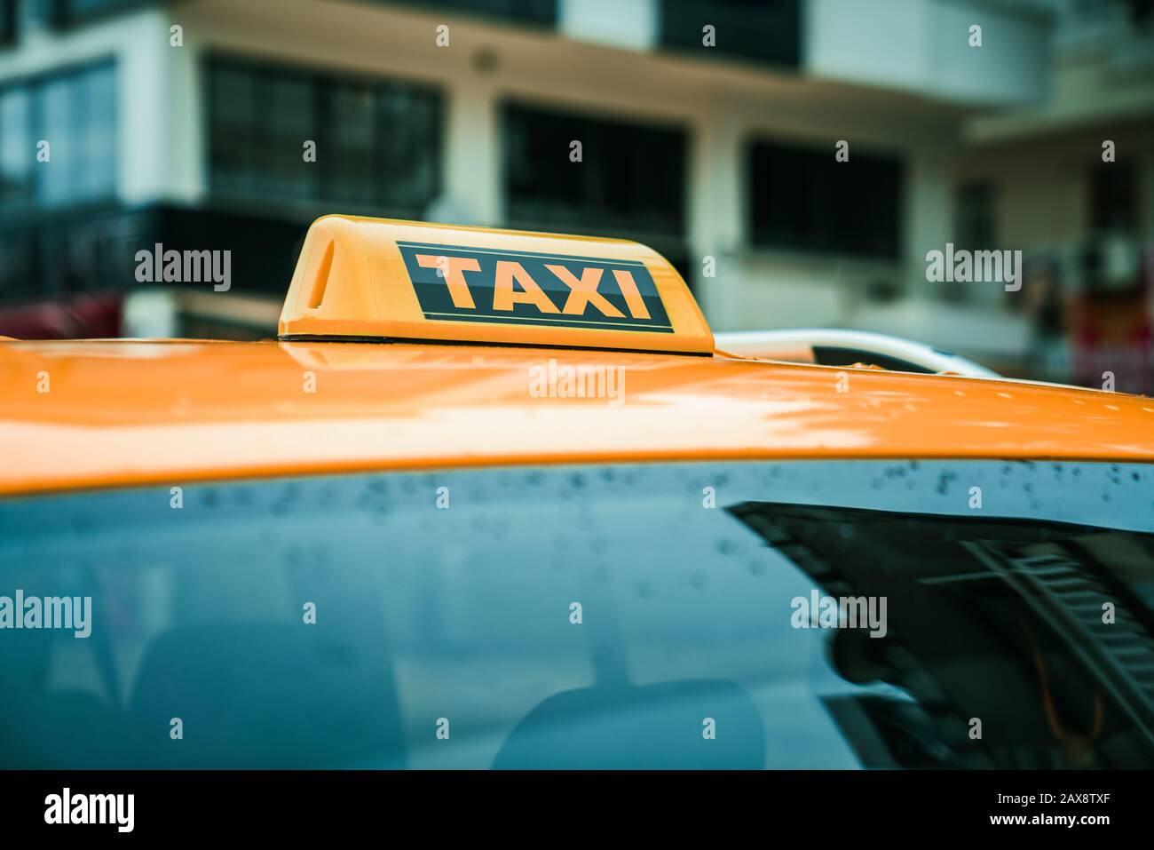 Panneau jaune de taxi sur le toit d'une voiture. Concept de transport et de voyage Banque D'Images