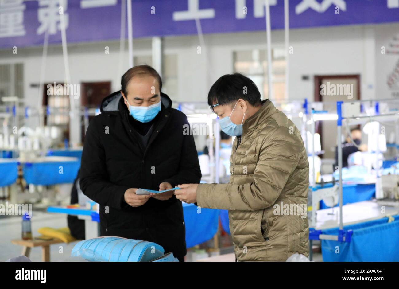 Les travailleurs chinois fabriquent des masques de visage dans une usine durant l'éclosion du nouveau coronavirus et de la pneumonie dans le village d'Aimian, dans la ville de Chang'an, à Rong'an Banque D'Images