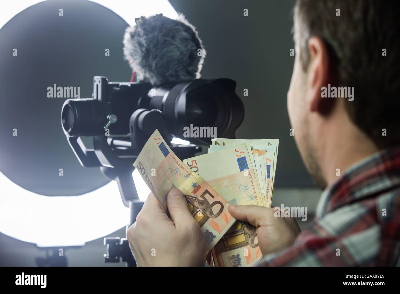 Vlogger mâle comptant de l'argent de vlogging Banque D'Images