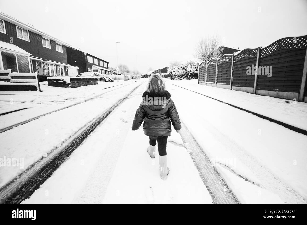 Une jolie petite fille, un tout-petit marchant et éprouvant sa première fois dans la neige, après une forte chute de neige à Stoke on Trent, Longton, fermeture de pépinière Banque D'Images