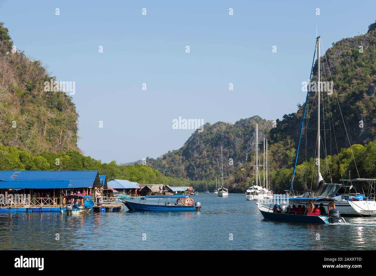Les bateaux transportent des touristes musulmans à la ferme de poissons de Paksu, au parc géoforestier de Kilim Karst, à Langkawi, en Malaisie Banque D'Images