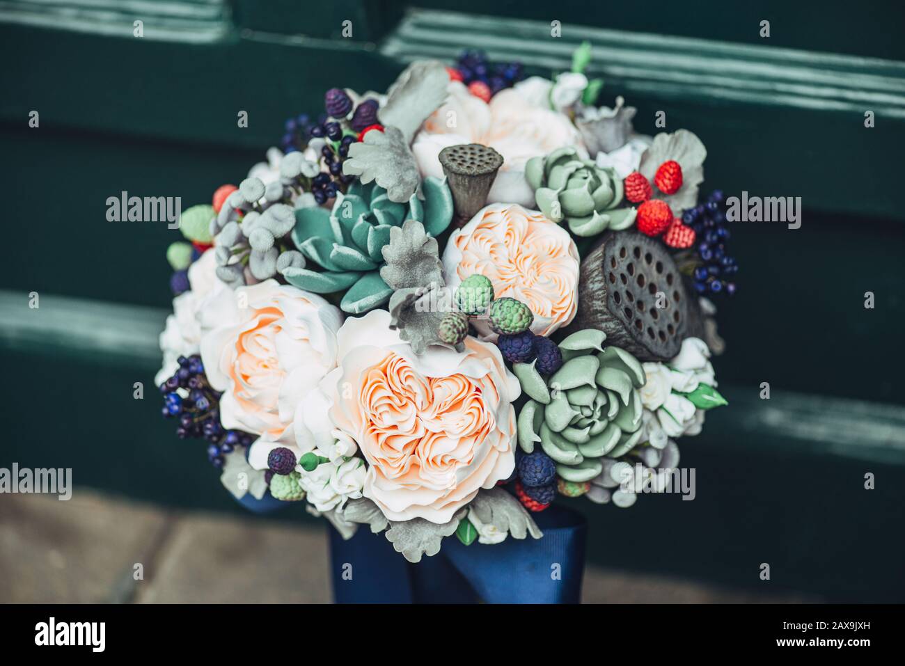 Fleurs faites à la main en argile polymère japonaise. Ils ressemblent à un véritable bouquet de mariage. Sur le fond d'une porte en bois vert Banque D'Images