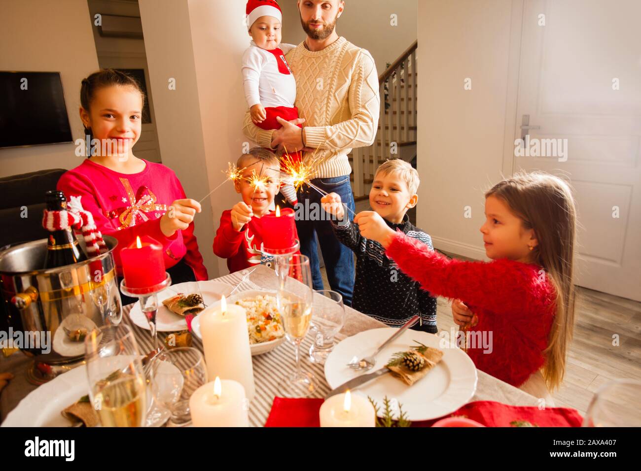 Joyeux enfant avec des parciateurs dans les mains à la fête de Noël à la maison. Banque D'Images