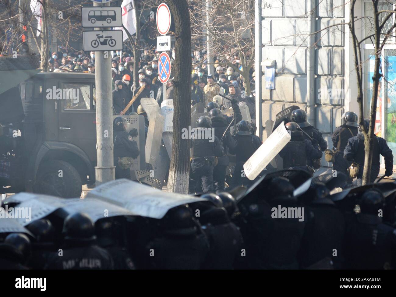 Des policiers armés de boucliers, des fusils de chasse à l'action de la pompe attaquent le barrage routier des manifestants. Révolution De La Dignité, rue Shelkovichnaya. 18.02.2014, Kiev, Ukrane Banque D'Images