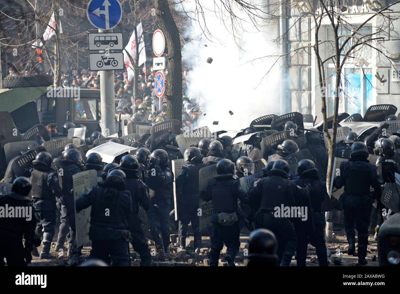 Des policiers armés de boucliers, des fusils de chasse à l'action de la pompe attaquent le barrage routier des manifestants. Révolution De La Dignité, rue Shelkovichnaya. 18.02.2014, Kiev, Ukrane Banque D'Images