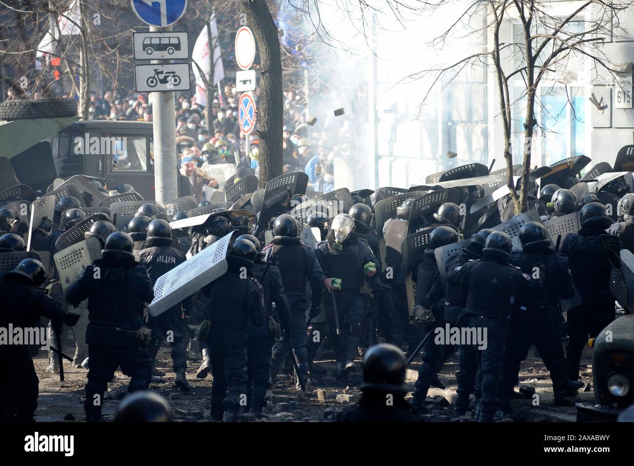 Des policiers armés de boucliers, des fusils de chasse à l'action de la pompe attaquent le barrage routier des manifestants. Révolution De La Dignité, rue Shelkovichnaya. 18.02.2014, Kiev, Ukrane Banque D'Images