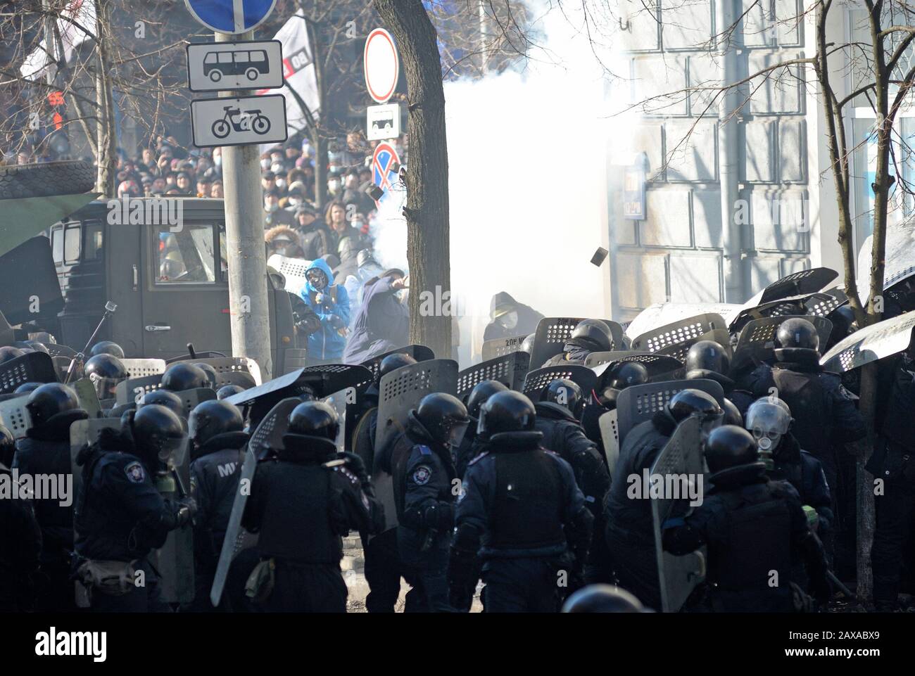 Des policiers armés de boucliers, des fusils de chasse à l'action de la pompe attaquent le barrage routier des manifestants. Révolution De La Dignité, rue Shelkovichnaya. 18.02.2014, Kiev, Ukrane Banque D'Images